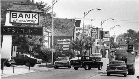 Archival black-and-white photograph of downtown Westmont, Illinois, showing the Bank of Westmont sign and Cass Avenue commercial corridor